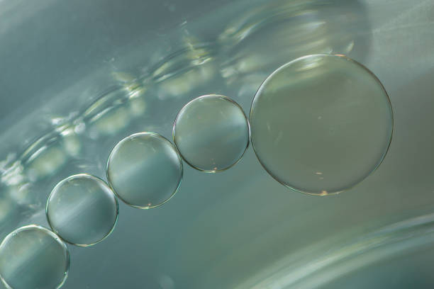 istock Close up oil drops floating on water . 1457933228