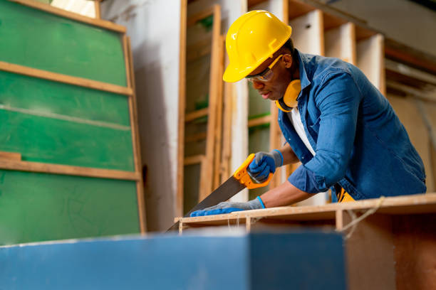 istock African American carpenter man use sawing wood to work with timber on table during work in factory workplace area. 1457935064