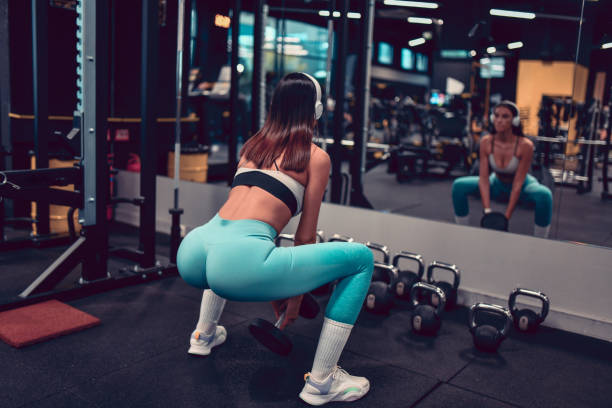 덤벨 스쿼트 by 운동 여성 체육관 - dumbbell women body building exercises flexing muscles 뉴스 사진 이미지