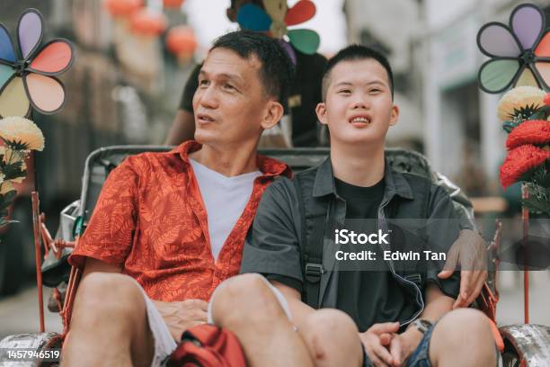 Asian Chinese Down Syndrome Young Man Enjoying Rickshaw Ride In Penang Street With Father Stock Photo - Download Image Now