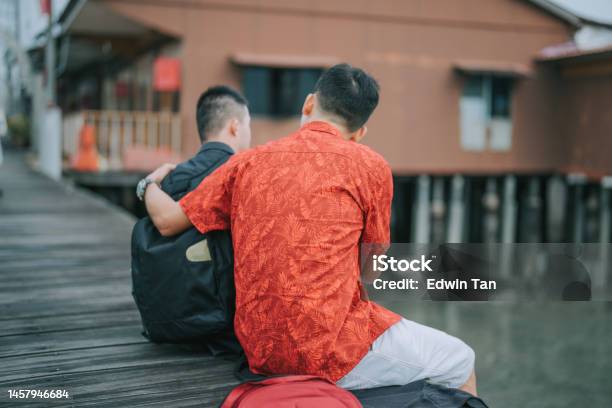 Asian Chinese Father Talking T O Down Syndrome Son Siting On Footbridge In Penang Travel Stock Photo - Download Image Now
