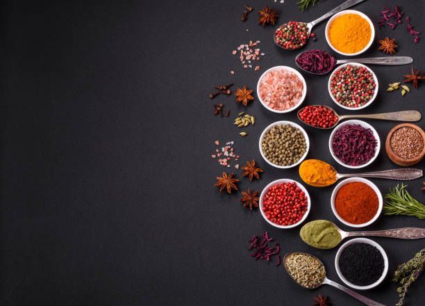 Composition consisting of variations of spices in white bowls and metal spoons Composition consisting of variations of spices in white bowls and metal spoons on a dark concrete background condiment stock pictures, royalty-free photos & images