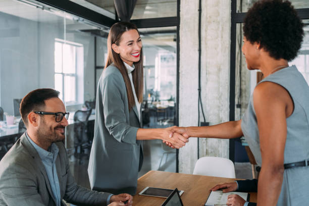 istock Businesswomen shaking hands across the table. 1457947726