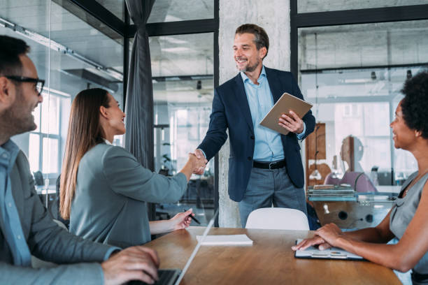 femme d’affaires et homme d’affaires se serrant la main à travers la table. - winning success business businessman photos et images de collection