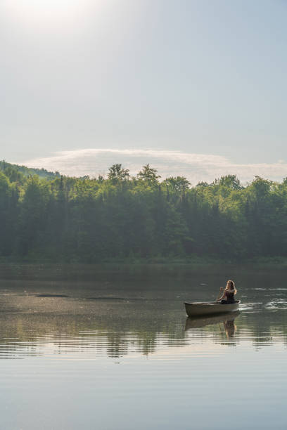 istock A woman canoeing in early morning. 1457949461