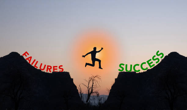 istock Professional jumping from failures to success conceptual with mountains 1457951729
