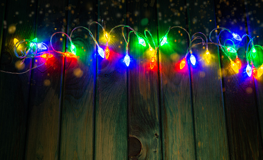 Colourful lights on wooden table with copy space - Christmas celebration theme.