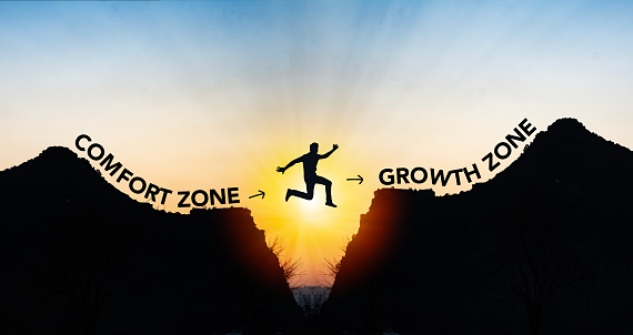 Man jumping from comfort zone to growth zone. Success and change concept .