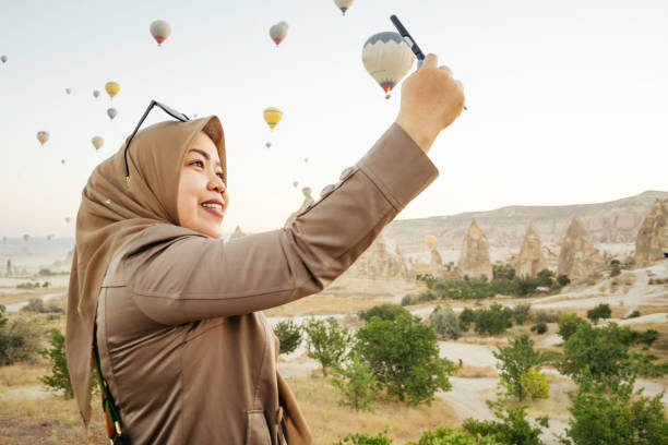 istock asian woman taking selfie portrait using handphone camera 1457954050