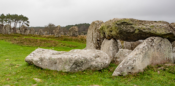 Carnac, Brittany, France on January 13,2023: famous field of megaliths, their real purpose is still unknown today; the dolmen in front is a burial site