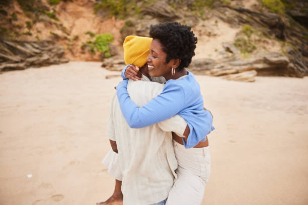 istock Mature couple hugging each other on a sandy beach 1457956032