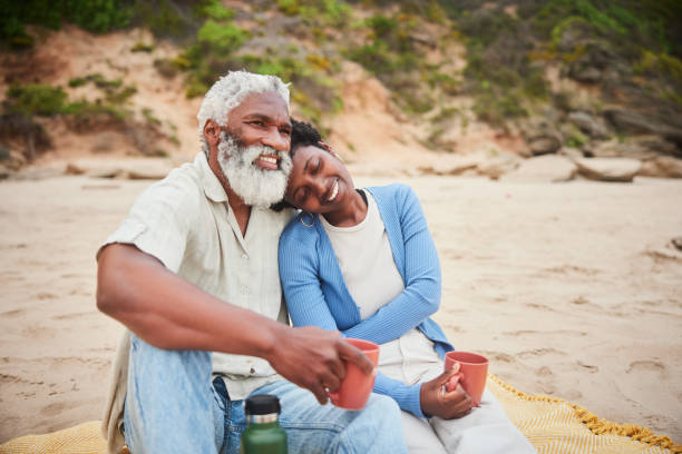 istock Loving mature couple relaxing on a sand beach with coffee 1457956578
