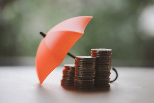 parapluie sur des piles et des tas de pièces de monnaie, fond nature. concept de couverture, d’assurance ou de protection. - umbrella protection savings currency photos et images de collection