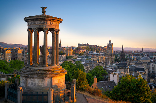 Looking over the buildings and roofs of Edinburgh Old Town to the cliffs of Salisbury Crags and the peak of Arthur's Seat.