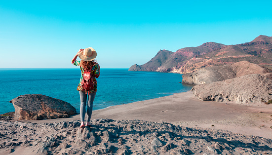 Woman tourist looking at panoramic landscape of Cabo de Gata near Almeria,  Andalusia in Spain
