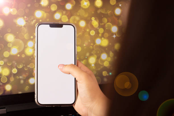 istock woman holding a cell phone with yellow bokeh background 1457965183