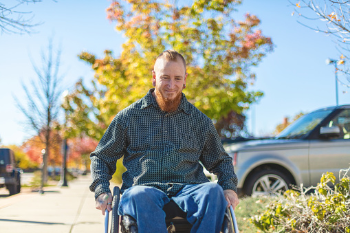 Male with Paralysis Disability in Wheelchair on Small Town Western USA City Street in Autumn Photo Series - Matching 4K video available