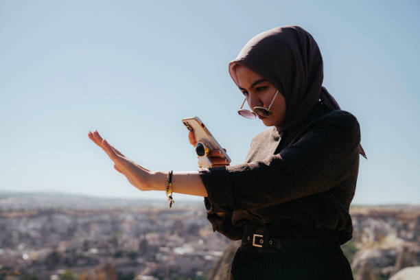 istock asian woman taking selfie portrait using handphone camera 1457965792