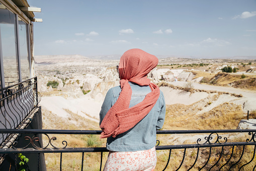 asian muslim woman standing in cafe  seeing the goreme park