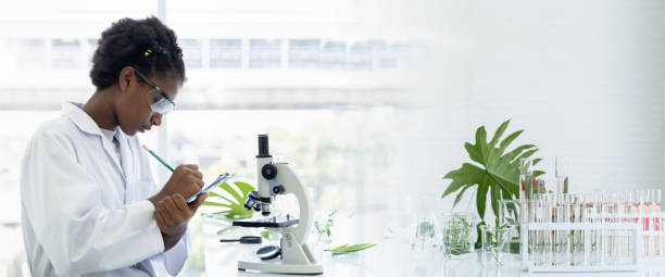 istock African American girl scientists learning and writing science and researching through microscope in the laboratory. Science and education, researcher and discovery concept 1457967360