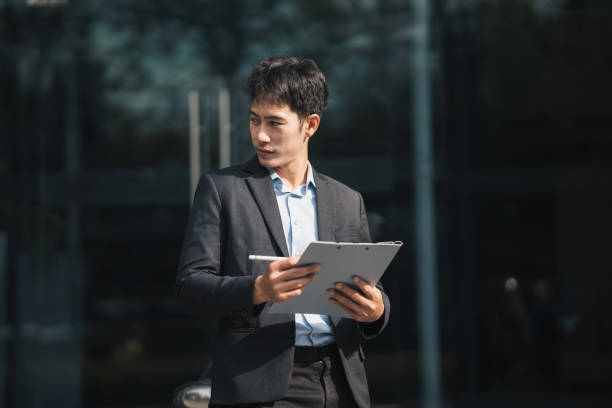 istock Handsome young manager working on laptop while sitting outdoors on the stairs, concept of work life balance. 1457967672