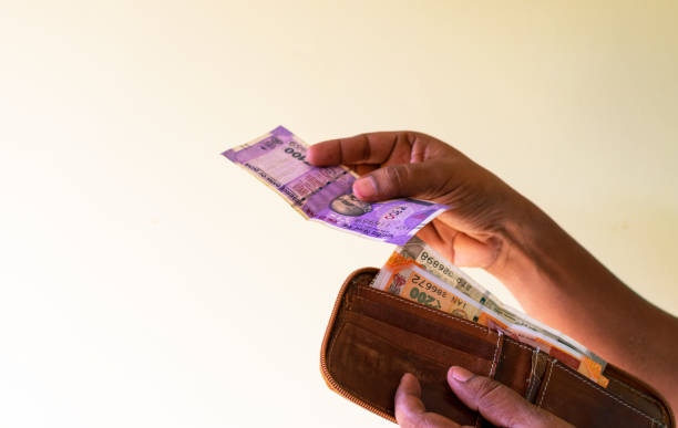 istock Crop view of young man hands while taking Indian currency notes from wallet. 1457970116