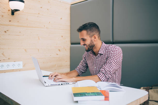 istock Cheerful male using laptop relaxing at workplace 1457973103