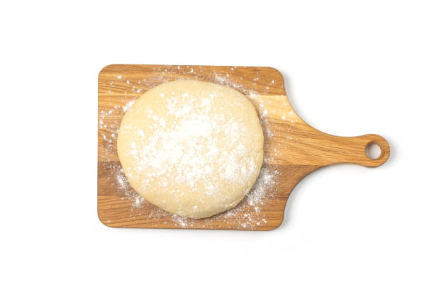 istock Fresh yeast dough isolated on wooden cutting board on white background 1457973162