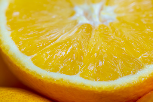 Slice of split orange fruit in an appetizing-looking macro photo