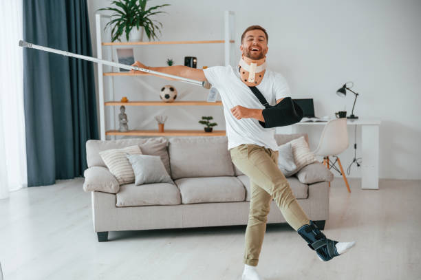 istock Having fun, dancing. Man with crutches is at home indoors. Having injuries 1457975572