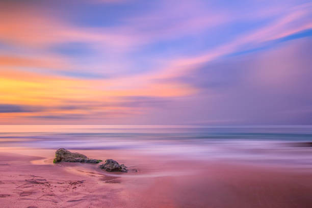 rocher de la mer contre le ciel au coucher du soleil - long exposure rock cloud sky photos et images de collection