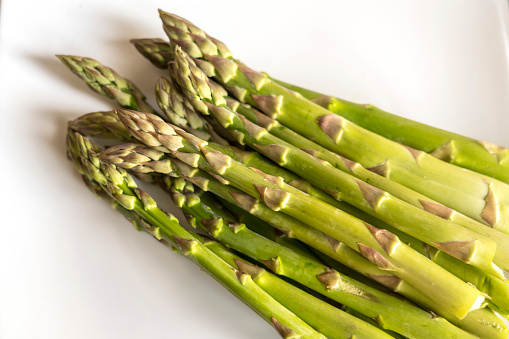 Bunch of raw fresh green asparagus on plate