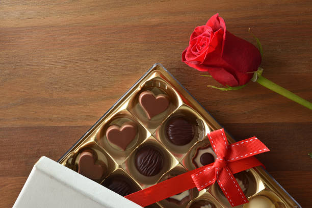 istock Romantic gift with chocolates with bow and rose on wooden 1457977983