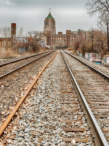 Railroad tracks in the Lincoln Park area of Detroit leads towards an office building in the Midtown area.