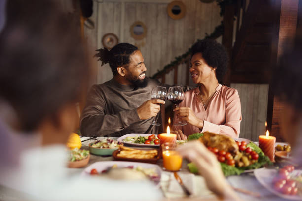 istock Happy black couple toasting during lunch at dining table. 1457989549