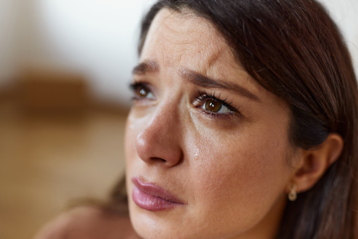 Close up of young sad woman crying.