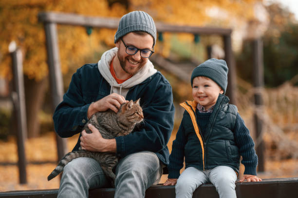 istock Petting a cat. Father and young son is together outdoors at daytime 1457993407
