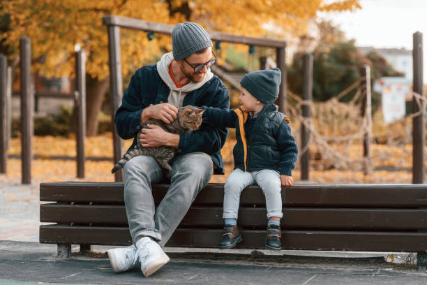 istock Petting a cat. Father and young son is together outdoors at daytime 1457993423