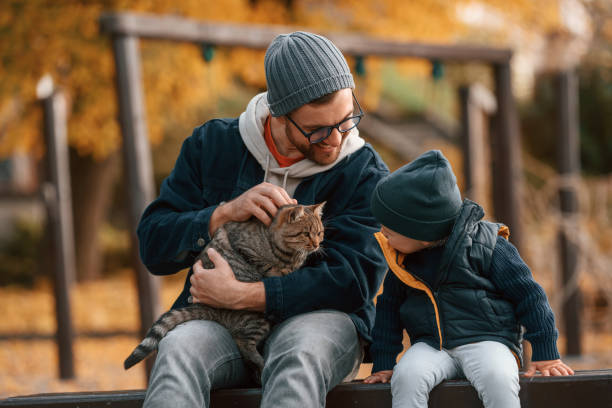 istock Petting a cat. Father and young son is together outdoors at daytime 1457993428