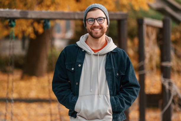 Beautiful man in warm clothes is outdoors in the park stock photo
