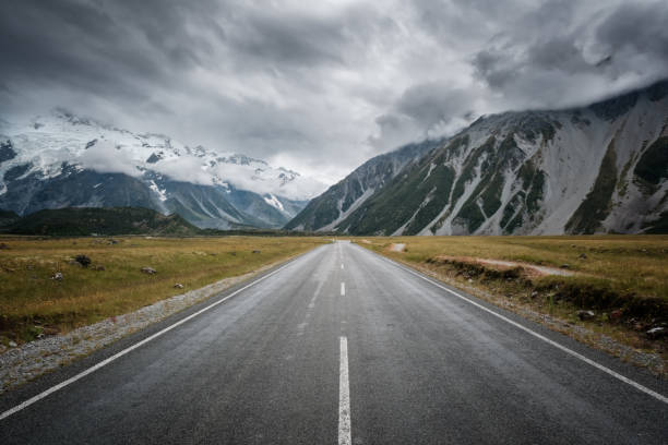 que conduce a montañas cubiertas de nieve en nueva zelanda - new zealand fotos fotografías e imágenes de stock