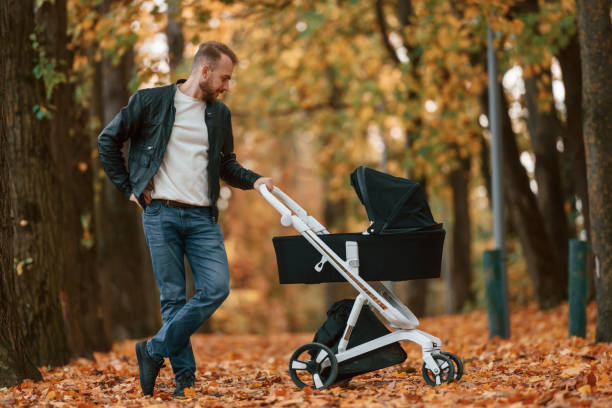 istock Man with pram is having a walk in the autumn park 1457994519