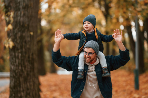 istock In warm clothes. Father and young son is together outdoors at daytime 1457994702