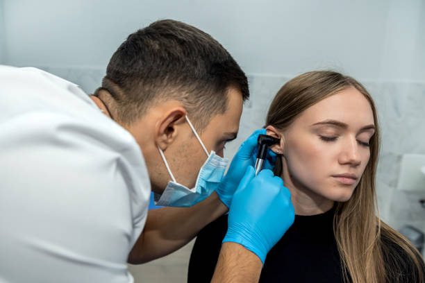 istock ENT doctor examines the patient's ear using an otoscope. 1457998472
