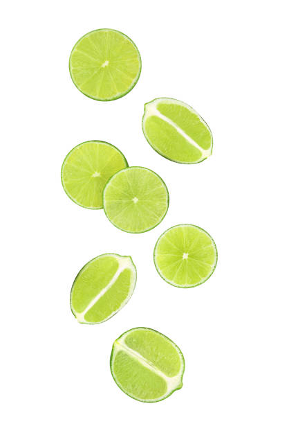 istock Slices of lime fruit falling in the air isolated on white 1457998522