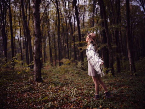 Happy woman breathing the fresh air during autumn day in the forest. Copy space. Photographed in medium format.