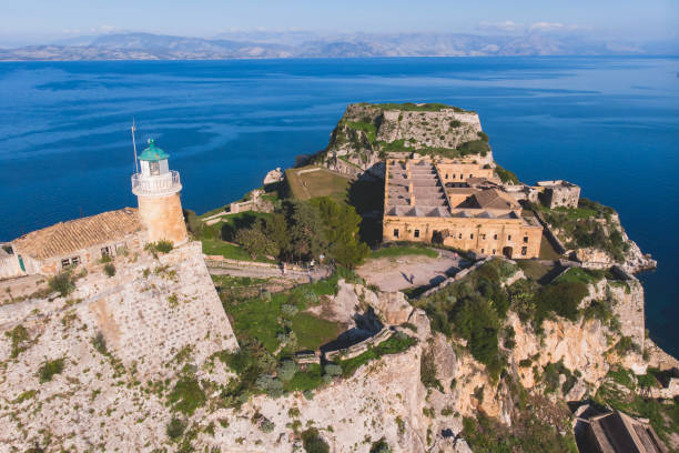 Aerial panoramic drone view of Old Venetian Fortress of Corfu, Palaio Frourio, Kerkyra old town, Greece, Ionian sea islands, with the lighthouse, church and scenery beyond the city in summer sunny day vista aérea panorámica de drones de la antigua fortaleza veneciana de corfú, palaio frourio, el casco antiguo de kerkyra, grecia, las islas del mar jónico, con el faro, la iglesia y el paisaje más allá de la ciudad en un día soleado de verano