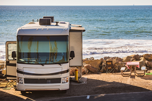 RV Campground on the Seashore with Scenic View. Motorhome Traveling Theme.