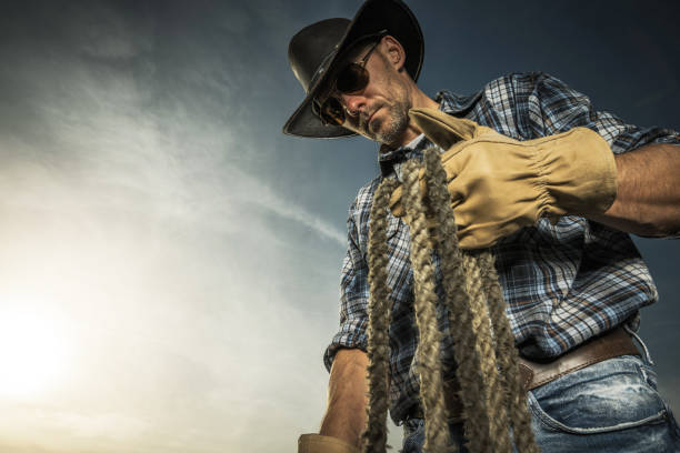 Smiling mature hispanic man looking at the camera wearing a cowboy hat