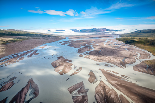 Summer greenlandic wastelands landscape with glacier river bend and mountains in the background, Qinnguata Kuussua River, Russel glacier in the background. Kangerlussuaq, Greenland